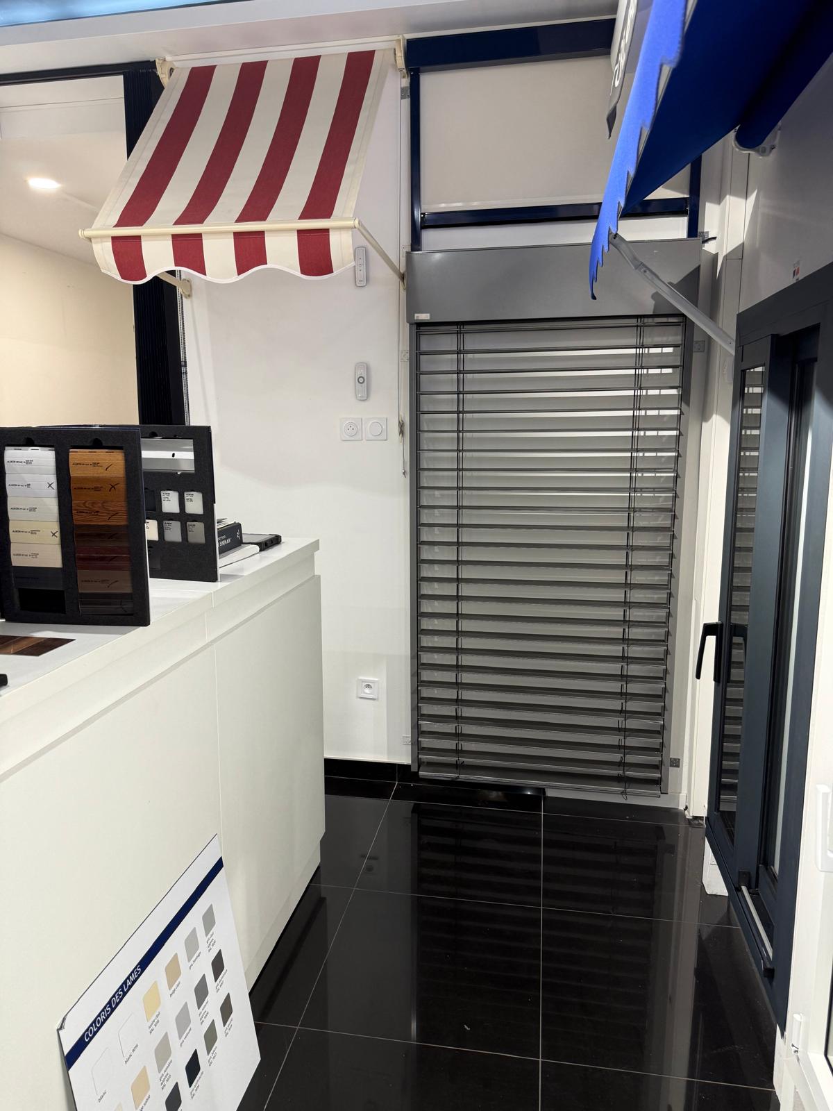 Store banne, volet roulant et brise-soleil exposés au showroom
