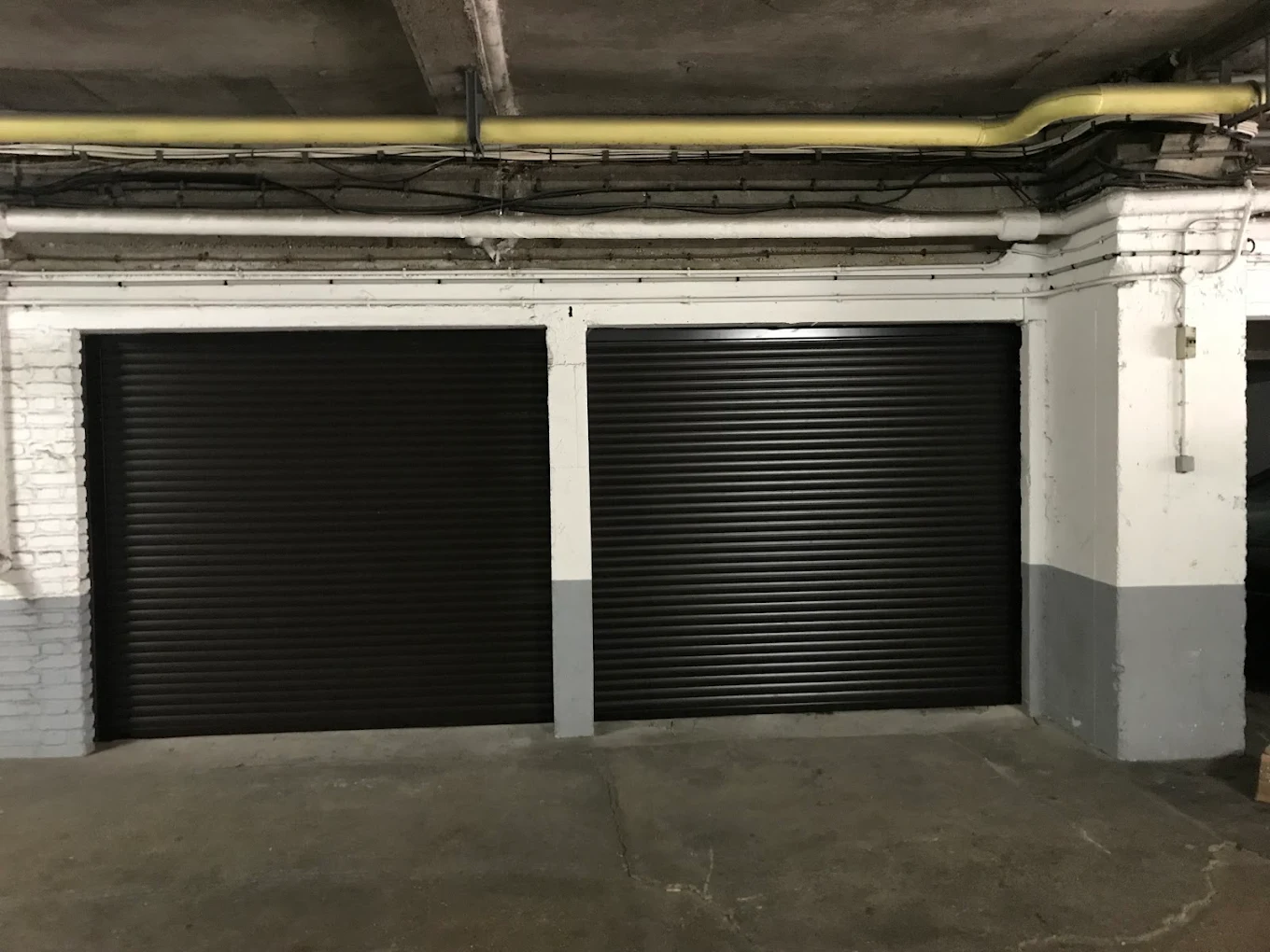 Deux rideaux métalliques noirs de box en sous-sol