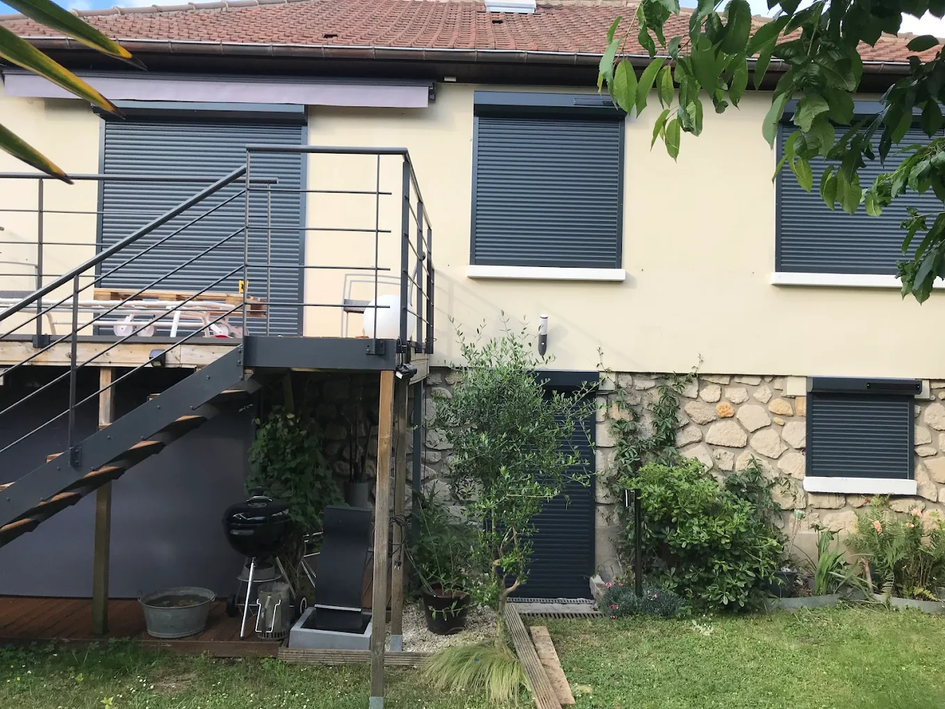 Volets roulants anthracite posés sur une façade de pavillon
